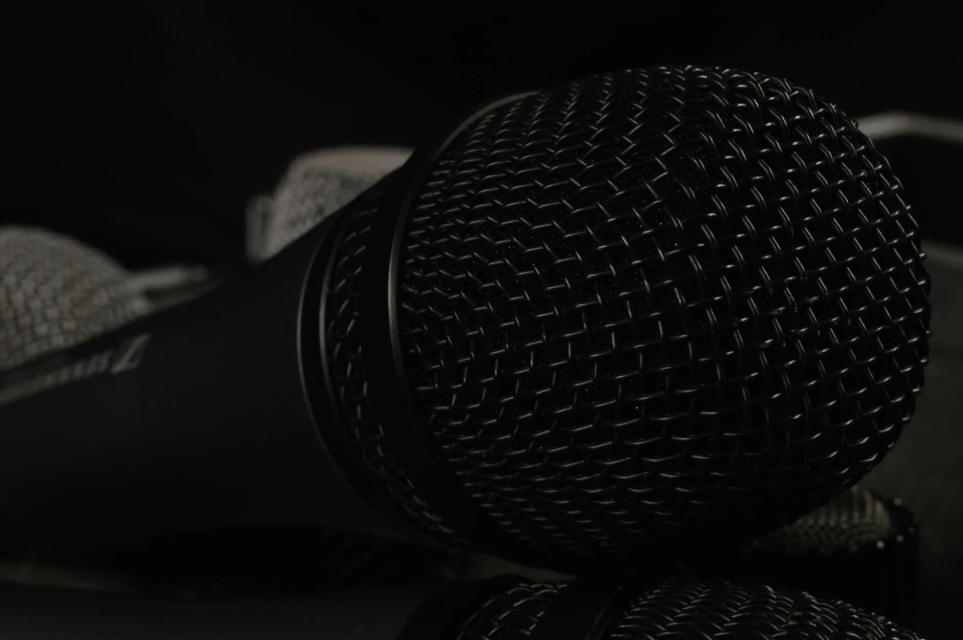 A dimly lit recording studio with a musician at a microphone, launching next release.