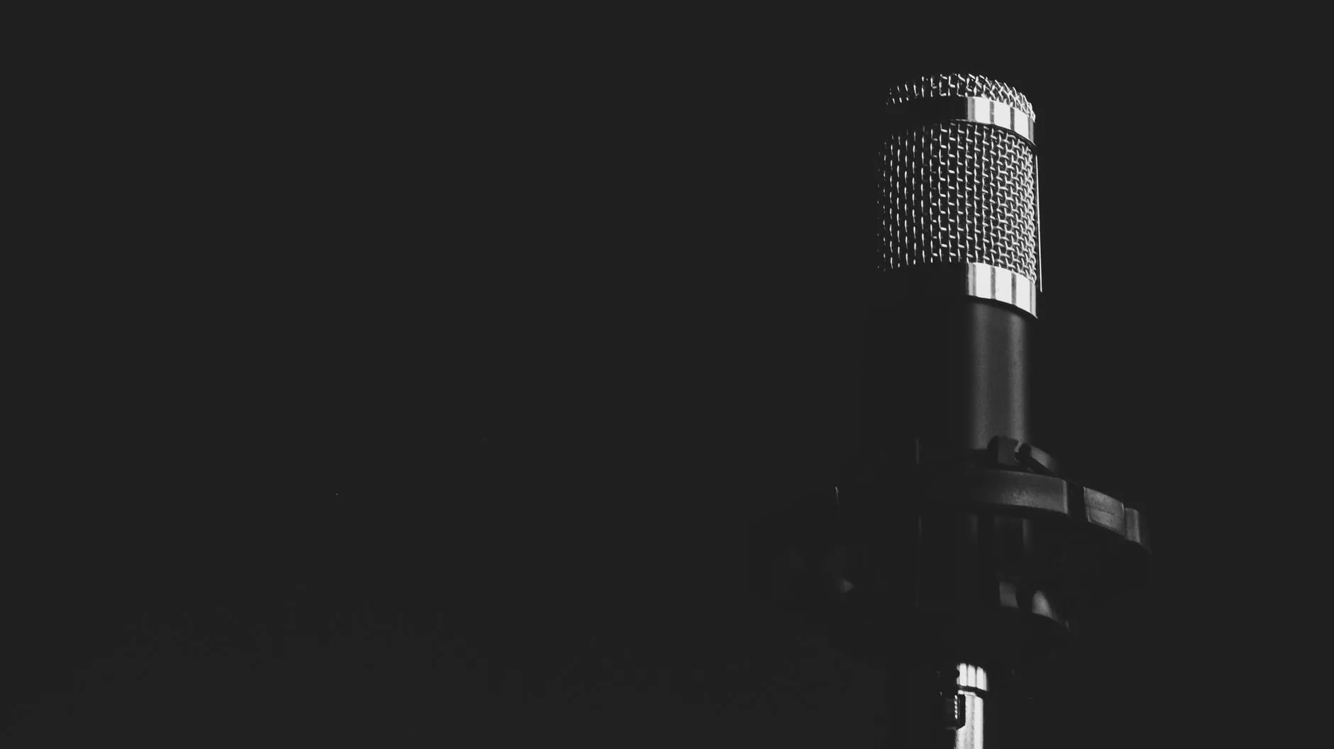 Musician in dimly lit recording studio, cluttered with equipment, back turned, artist statements resonate.